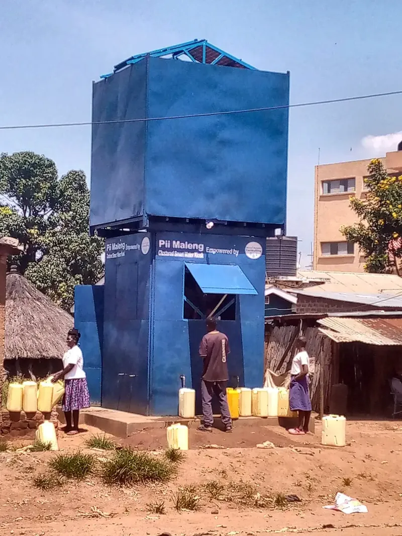 A Pii-Maleng kiosk with its water tank raised on pillars, serving a trading centre