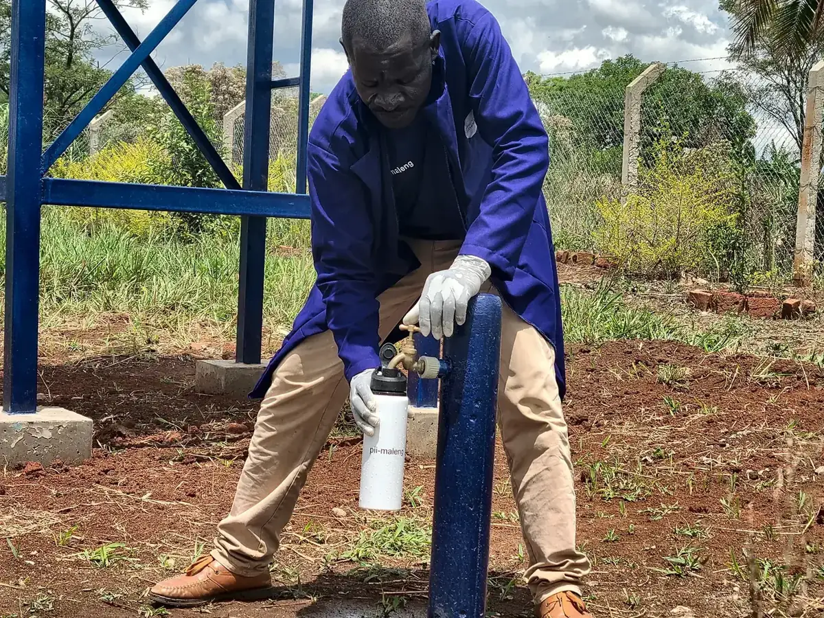 A Pii-Maleng water quality officer taking a water sample for testing
